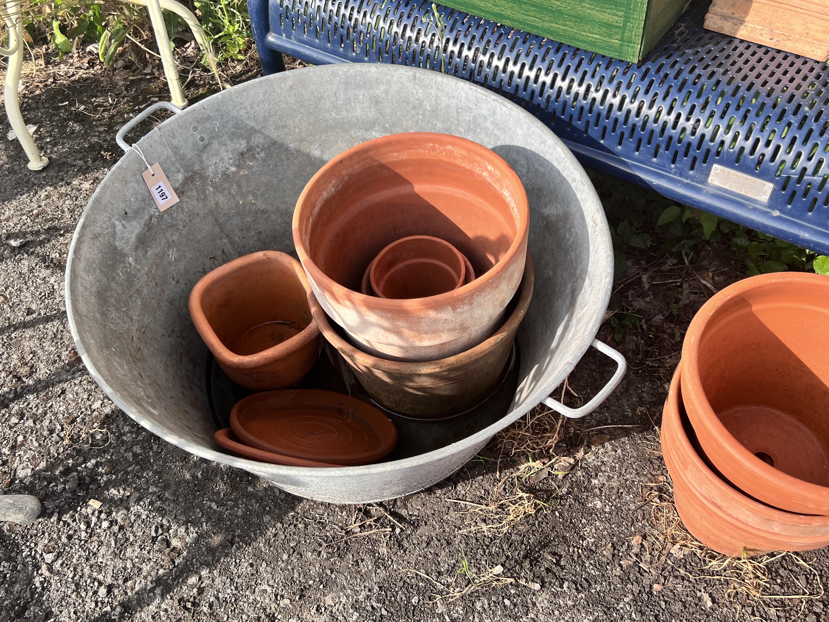 A large circular galvanised tub, diameter 72cm, together with a quantity of assorted terracotta garden pots